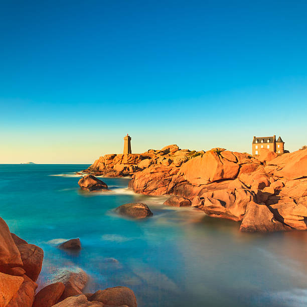 Ploumanach lighthouse sunset in pink granite coast, Brittany, Fr Ploumanach Mean Ruz lighthouse red sunset in pink granite coast, Perros Guirec, Brittany, France. Long exposure. brittany france stock pictures, royalty-free photos & images