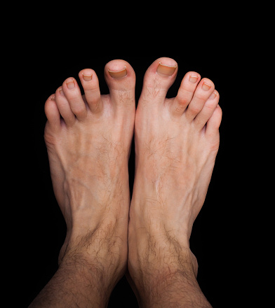 Pair of caucasian male feet isolated towards black