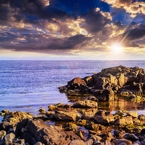 istock sea wave breaks about boulders at sunset 476770227