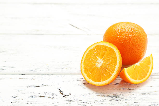 istock Ripe oranges on white wooden background 476771600
