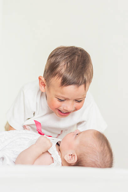 istock Little Cute Boy Playing with His Infant Sister 476773028