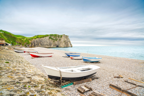 Etretat village, its bay beach, Aval cliff and boats. Normandy, France, Europe.
