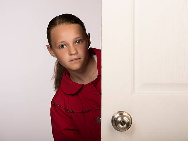istock Girl looking from behind a door 476787320