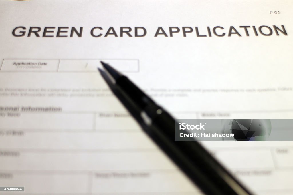 Green Card Application Someone filling out Green Card Application Form. 2015 Stock Photo