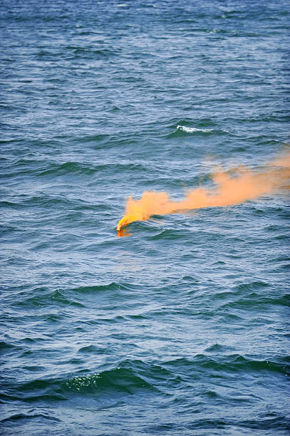 istock Orange smoke flare in the water 476801606