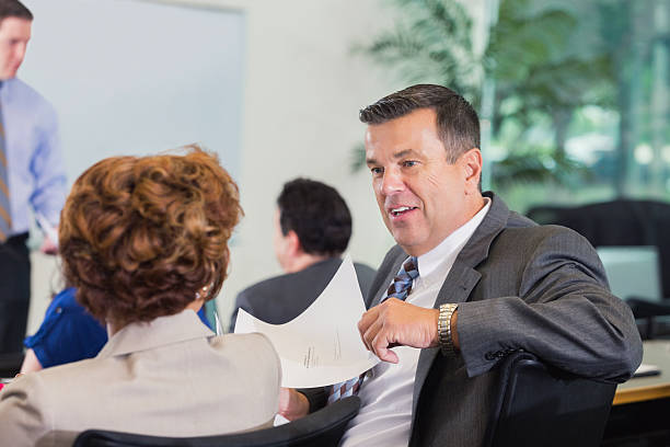 istock Mature businessman discussing financial document with coworker during seminar 476802134