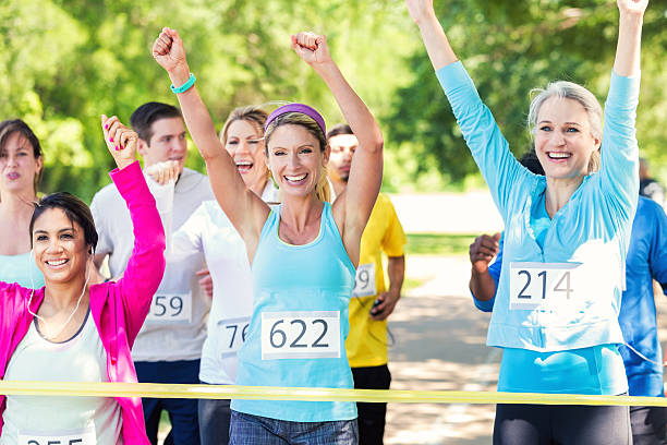 istock Diverse group of runners celebrating while crossing finish line 476802136