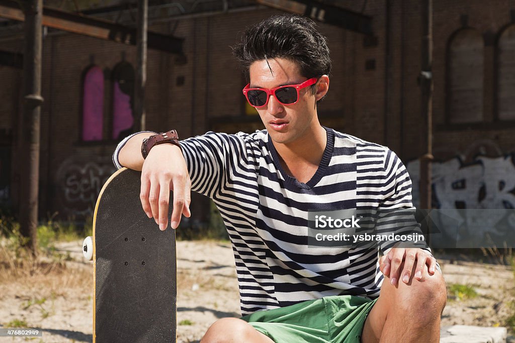 Miejski azjatycki człowiek z czerwone Okulary przeciwsłoneczne i Deskorolka. - Zbiór zdjęć royalty-free (Azjaci)