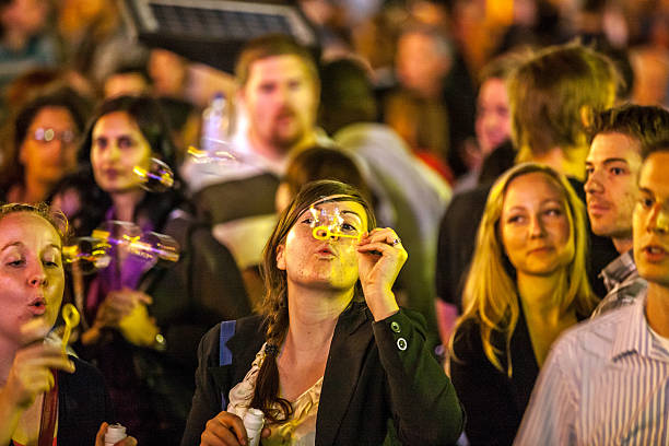 Toronto, Canada - June 24, 2011: Crowd of diverse people on Toronto street watching free open air entertainment. Two women blowing bubbles