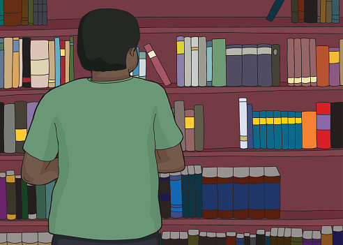 Single African man looking at bookshelves