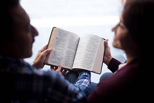 casal feliz com livro - bible holding reading book imagens e fotografias de stock