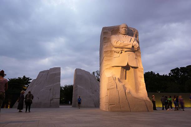 The Martin Luther King, Jr. Memorial located in Washington, DC Washington, United States - August 18, 2014: People meander about the Martin Luther King, Jr. Memorial in West Potomac Park, southwest of the National Mall, during the nighttime. The memorial honors civil rights leader Martin Luther King, Jr. (1929-1968) and was sculpted by Chinese sculptor Lei Yixin (born 1954). martin luther king jr memorial stock pictures, royalty-free photos & images