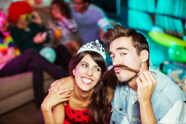 istock Smiling couple playing together at party 476806143