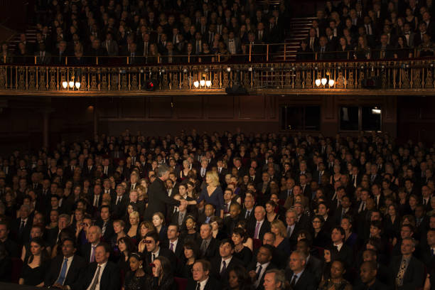 istock Spotlight on audience members handshaking in theater 476806631