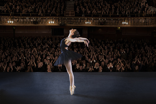 Ballerina performing on stage in theater photo