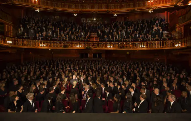 Photo of Spotlight on audience member using cell phone in theater