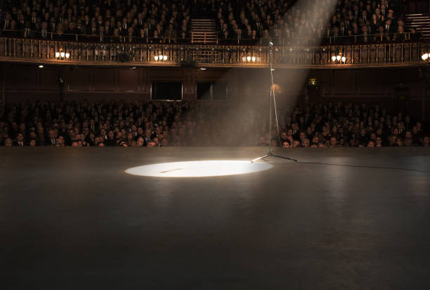 Blurred view of theatre interior with stage, comfortable seats and beautiful chandelier