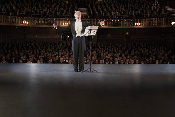 Woman in tuxedo conducting with baton