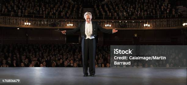Conductor Performing On Stage In Theater Stock Photo - Download Image Now - Musical Conductor, Audience, Bowing