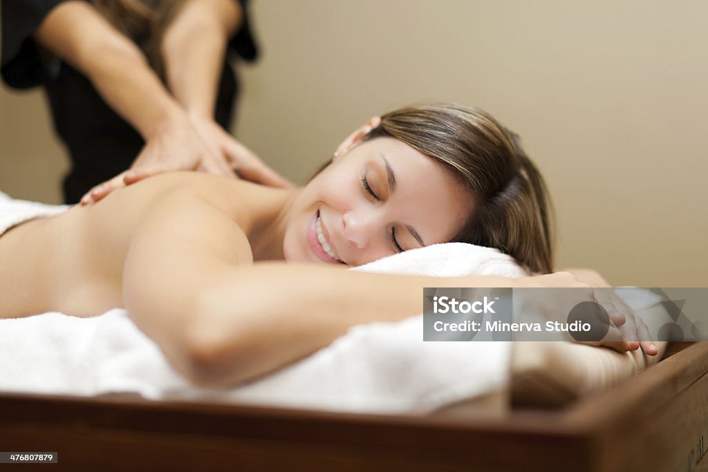 Young woman receiving a massage Young woman receiving a massage in a spa Massaging Stock Photo