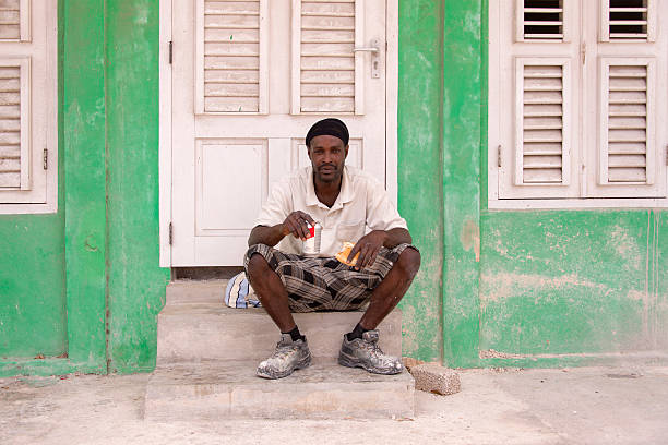 Willemstad, Curacao - March 23, 2015: Young man sitting on some steps having his lunch break.