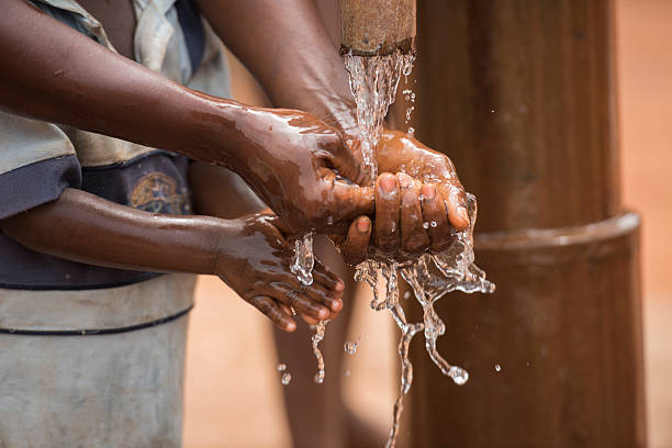 Mother and child washing hands with clean water stock photo