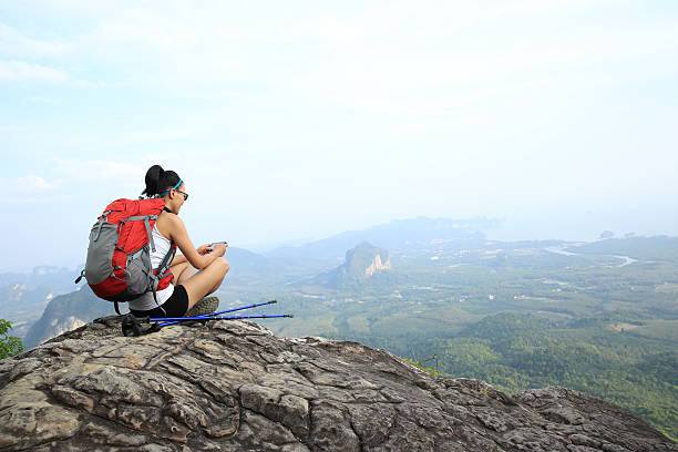 istock young woman hike use smart phone at mountain peak 476813018