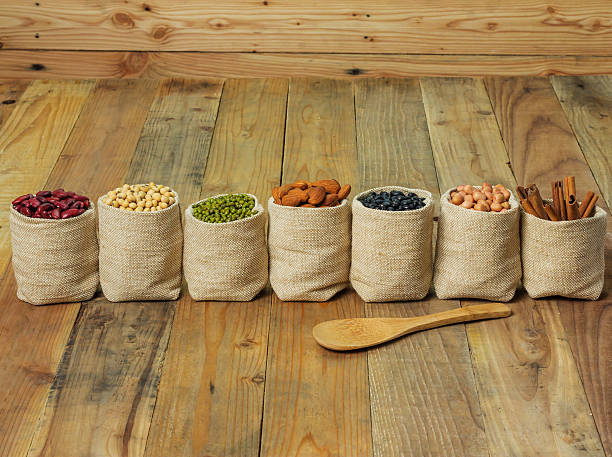 istock Different kinds of beans in sacks bag on wooden background 476814418