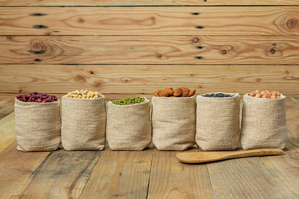 istock Different kinds of beans in sacks bag on wooden background 476814420