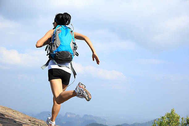 istock young asian woman hiker running on mountain peak cliff 476817964