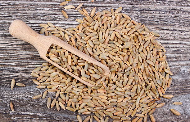 istock Rye grain with spoon on wooden background 476818122