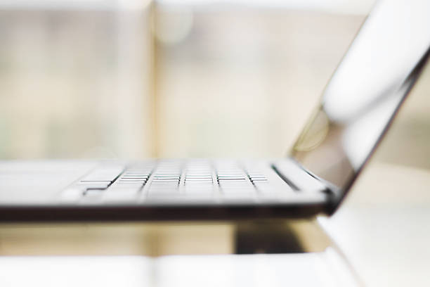 istock modern laptop on a glass table, shallow depth of field 476825616