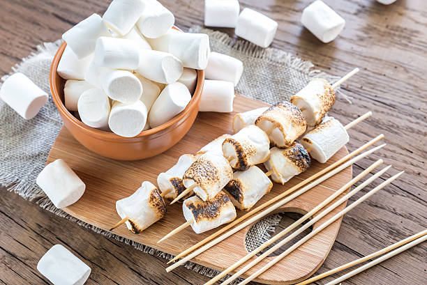 Marshmallow skewers on the wooden board stock photo