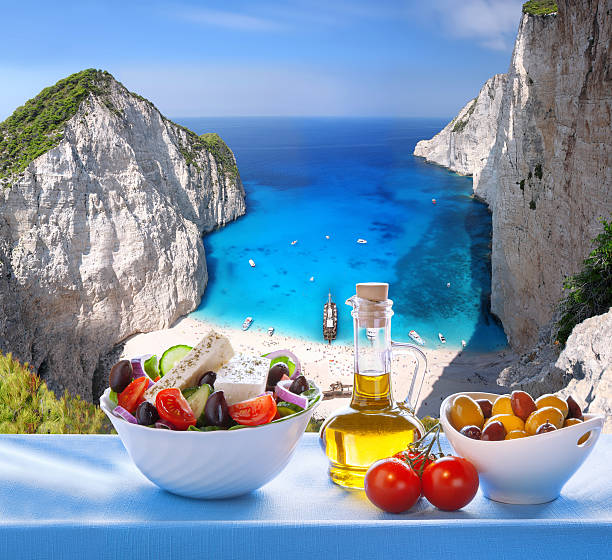 Navagio beach with Greek salad in Zakynthos, Greece Famous Navagio beach with Greek salad in Zakynthos, Greece table ledge stock pictures, royalty-free photos & images