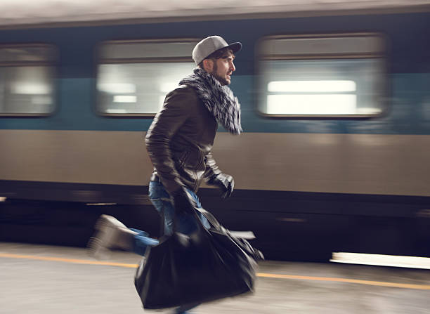 Man in blurred motion trying to catch the train. Young man running at railroad station and trying to catch the train. Blurred motion. running to catch the train stock pictures, royalty-free photos & images
