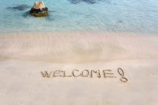 istock Welcome message written on white sand, sea waves in background 476831305