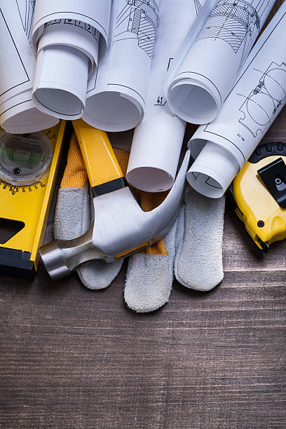 istock Rolls of blueprints hammer protective glove construction level t 476831436