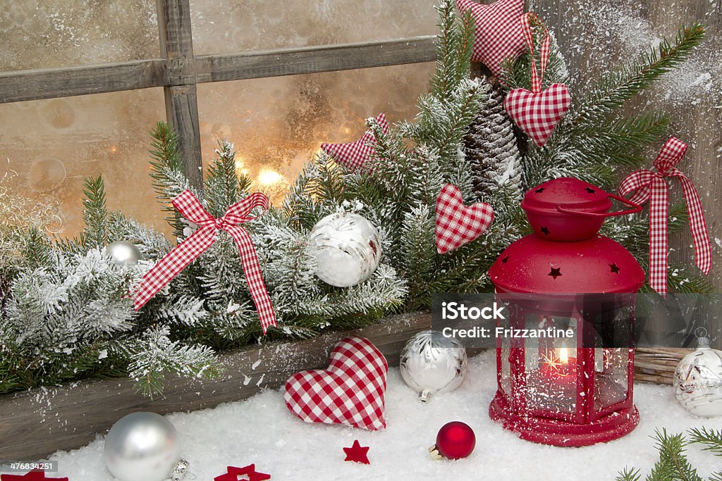 Red rustic christmas decoration with a latern and snow. Red rustic christmas decoration on window sill with red checked hearts in country style Art And Craft Stock Photo