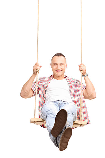 istock Carefree young man swinging on a swing 476834636
