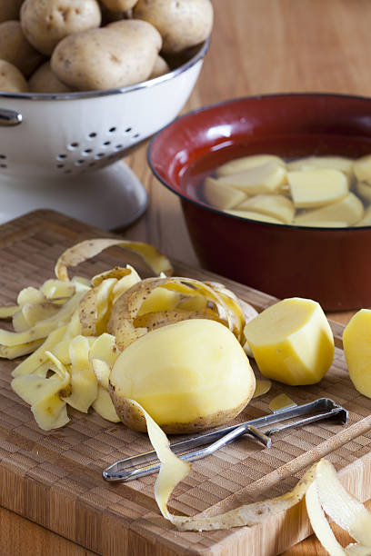 istock Raw potatoes and potato peeler 476836299