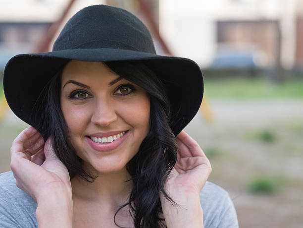 istock smiling young woman in black hat 476837142