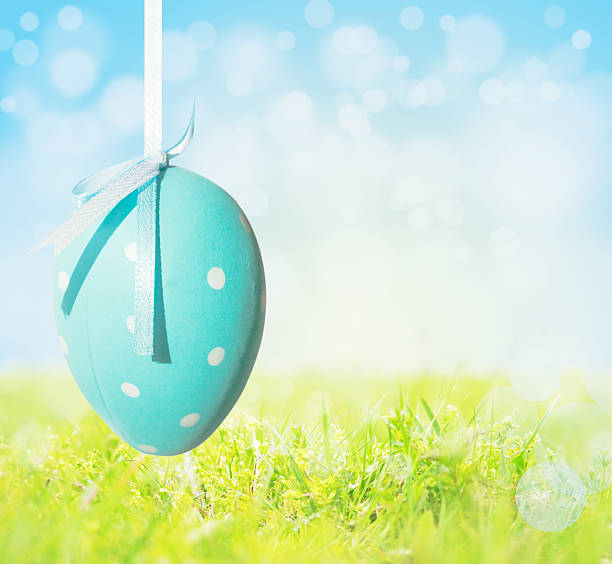istock Easter egg  on ribbon, background of spring meadow 476838131
