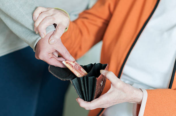 Woman takes money from the purse of a Senior women A woman takes money from open wallet a Senior women. The Senior keeps them by the arm. pickpocketing stock pictures, royalty-free photos & images