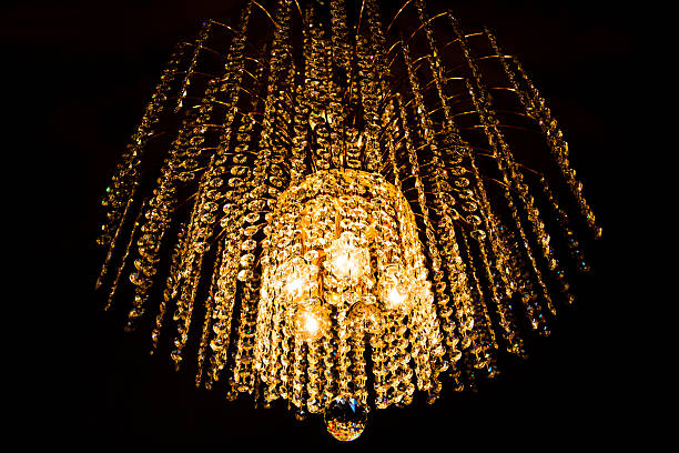 istock crystal chandelier glows with golden light 476844494