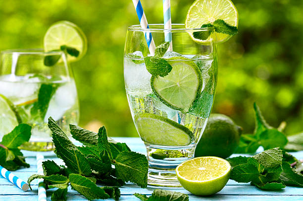Summer lemonade mojito . Summer lemonade mojito with lime and mint. lime basil plant stock pictures, royalty-free photos & images