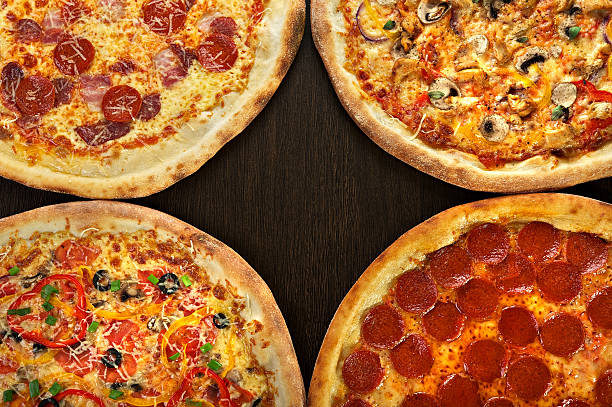 istock Four pizza on a dark wooden background 476849270