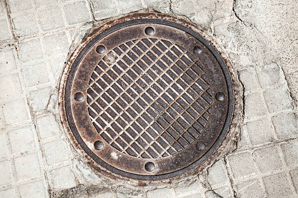 istock Round rusted hatch in urban pavement 476852782