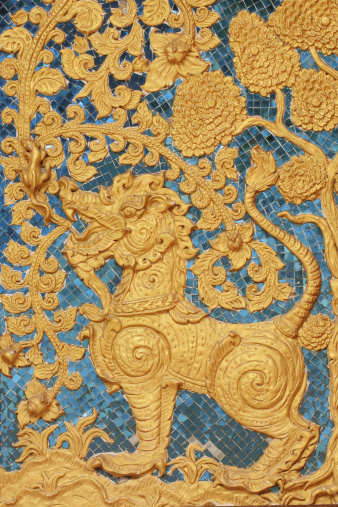 fairy tale leo in traditional thai style art molding at the wall of Thai temple.