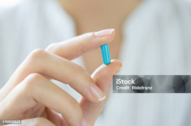 Hand Holding Blue Capsule Pill Stock Photo - Download Image Now - Pill, Capsule - Medicine, Medicine