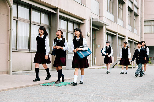 istock Japanese high school. Young students walk outside, building exterior, uniform 476863522